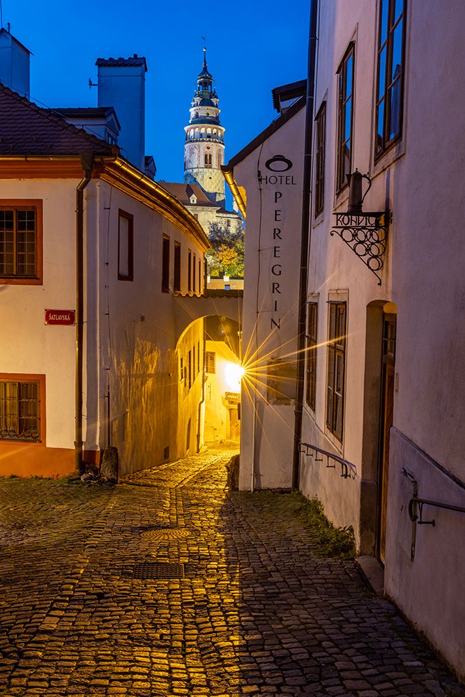 Narrow cobblestone streets at dusk with Castle Tower in historic Cesky Krumlov-Czech Republic.